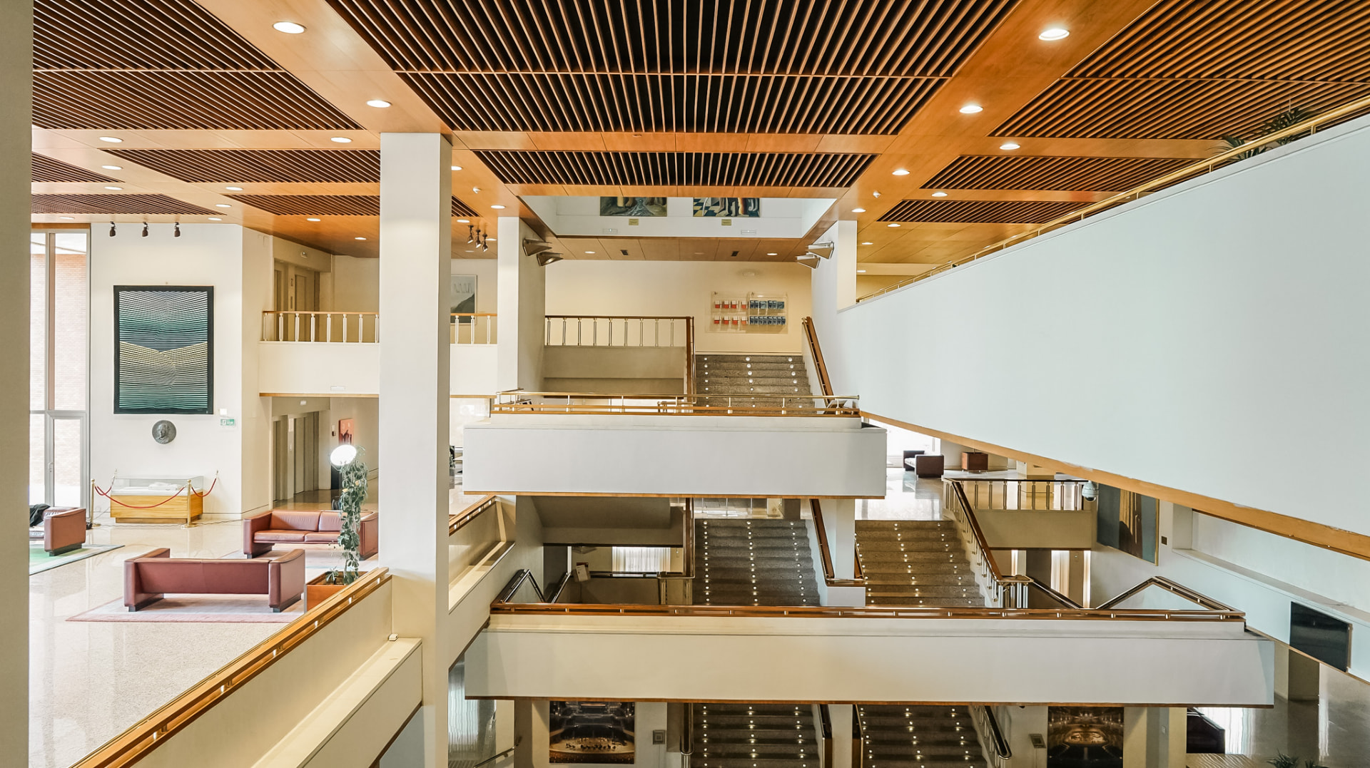 Vestíbulo de auditorio con escaleras y techos de madera
