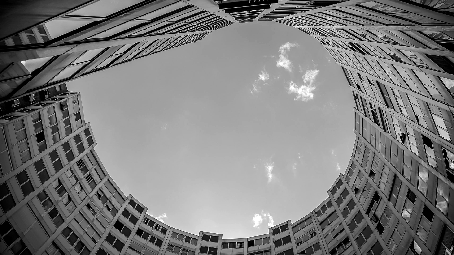 Edificios circulares vistos desde abajo formando un anillo sobre el cielo